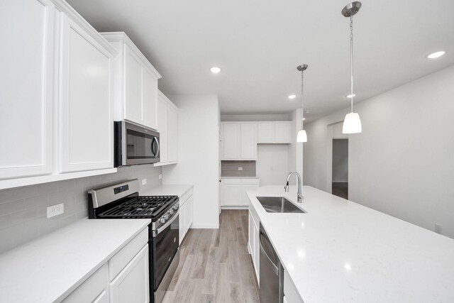 24727 Harrow Meadow Dr, Katy, TX 77493 - kitchen featuring tasteful backsplash, light wood finished floors, a sink, and stainless steel appliances
