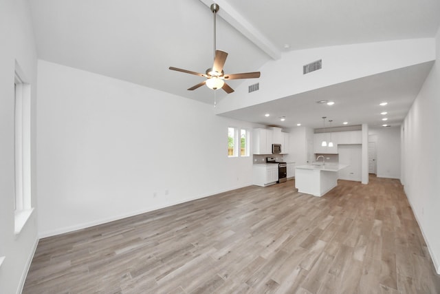 24727 Harrow Meadow Dr, Katy, TX 77493 - unfurnished living room with light wood-style floors, beamed ceiling, visible vents, and a sink