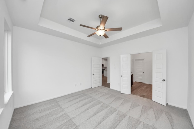 24727 Harrow Meadow Dr, Katy, TX 77493 - unfurnished bedroom with visible vents, baseboards, ceiling fan, carpet, and a tray ceiling