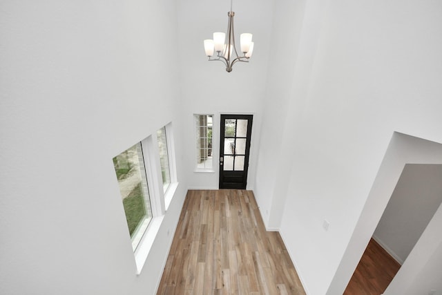 24727 Harrow Meadow Dr, Katy, TX 77493 - doorway with a high ceiling, a chandelier, wood finished floors, and baseboards