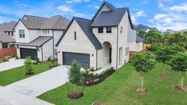 24727 Harrow Meadow Dr, Katy, TX 77493 - view of front of home featuring a garage, a front yard, driveway, and stone siding