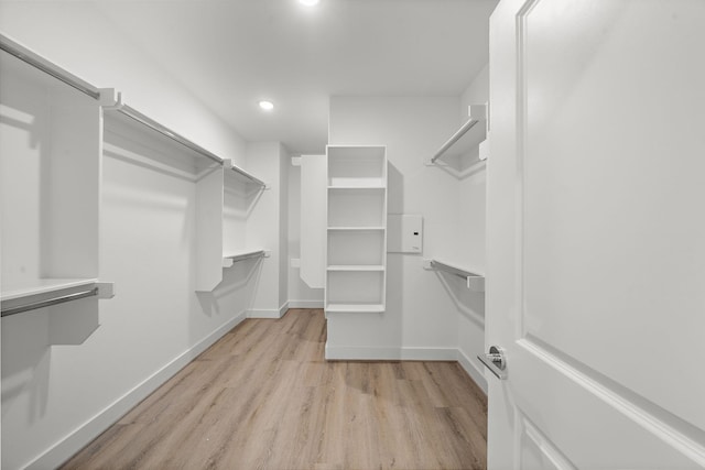 walk in closet with light wood-style flooring