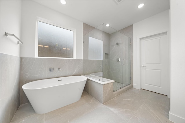 bathroom with a soaking tub, recessed lighting, marble finish floor, and a stall shower