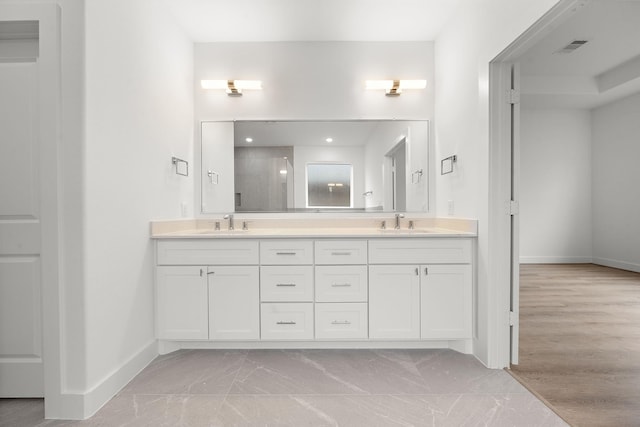 full bathroom with visible vents, a sink, baseboards, and double vanity