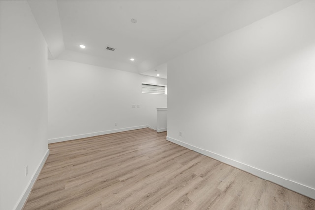 spare room featuring light wood finished floors, baseboards, visible vents, and recessed lighting