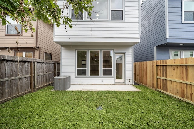 back of property with central air condition unit, a fenced backyard, a lawn, and a patio