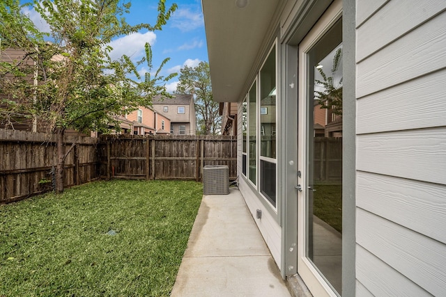 view of yard with a fenced backyard and central AC unit