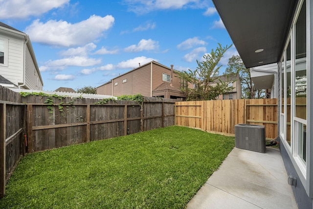 view of yard with a fenced backyard and central air condition unit