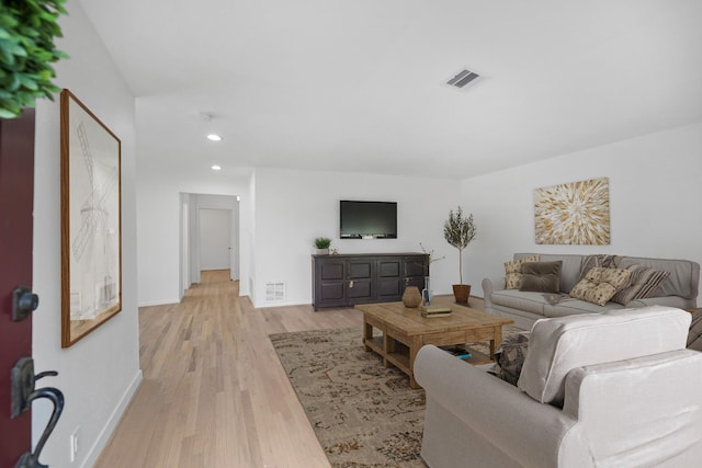 living room with light wood finished floors, baseboards, visible vents, and recessed lighting