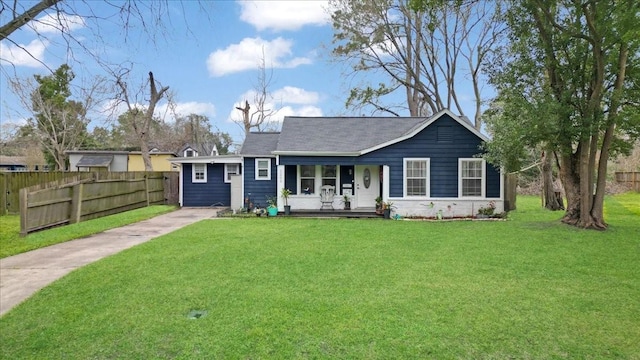 ranch-style house with covered porch, fence, and a front lawn