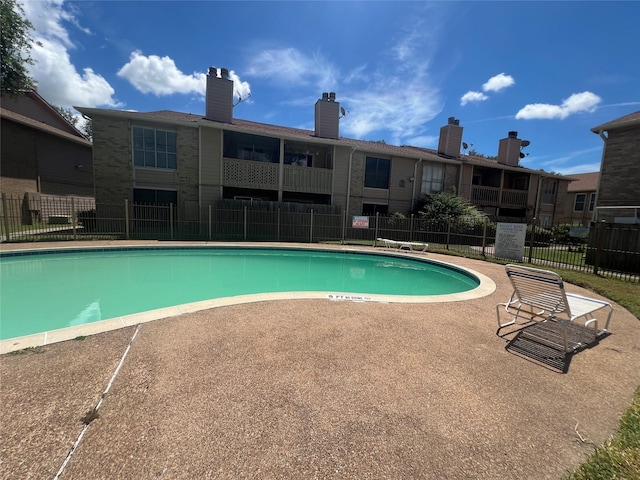 pool with a patio and fence