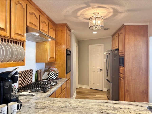 kitchen with light stone counters, visible vents, decorative backsplash, appliances with stainless steel finishes, and under cabinet range hood