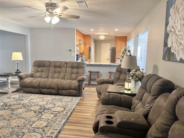 living room with recessed lighting, visible vents, ceiling fan, a textured ceiling, and light wood-type flooring