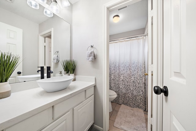 full bath with tile patterned flooring, vanity, and toilet