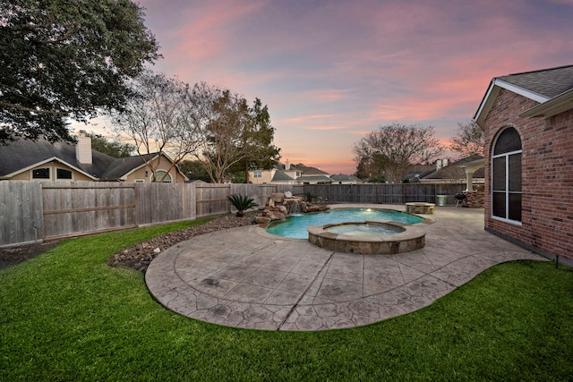 pool at dusk with a patio, a lawn, a fenced backyard, and a pool with connected hot tub