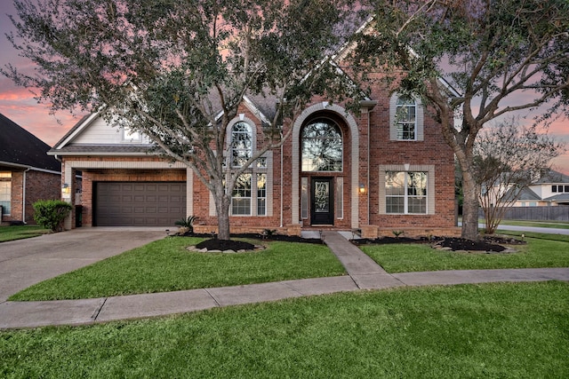 traditional-style house featuring driveway, a front lawn, and brick siding