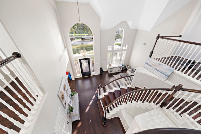 foyer entrance with high vaulted ceiling, stairway, and wood finished floors