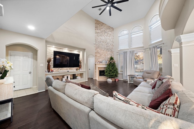 living area with ceiling fan, high vaulted ceiling, a fireplace, and wood finished floors