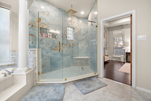 bathroom featuring tile patterned flooring, a shower stall, and decorative columns