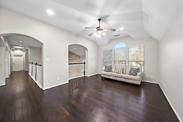 unfurnished living room featuring vaulted ceiling, dark wood finished floors, a ceiling fan, and baseboards