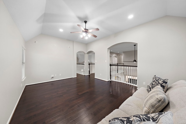 living area with baseboards, vaulted ceiling, a ceiling fan, and wood finished floors