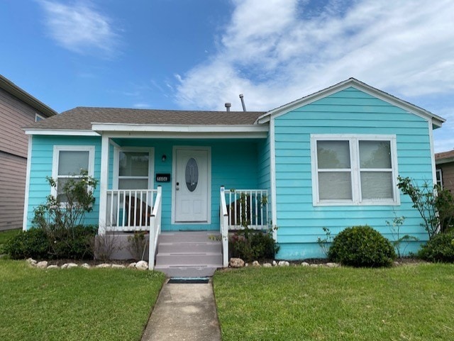 bungalow with a front yard and covered porch