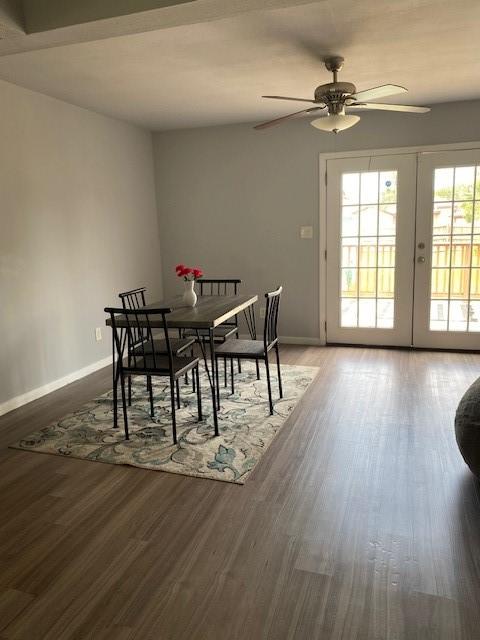 dining space featuring a ceiling fan, french doors, baseboards, and wood finished floors