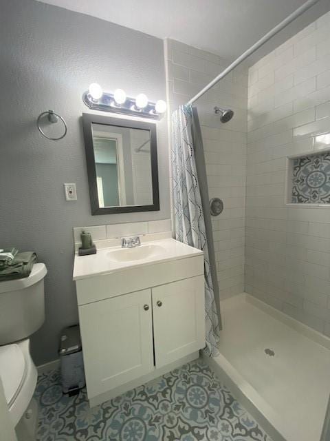 full bathroom with toilet, a shower stall, vanity, and tile patterned floors