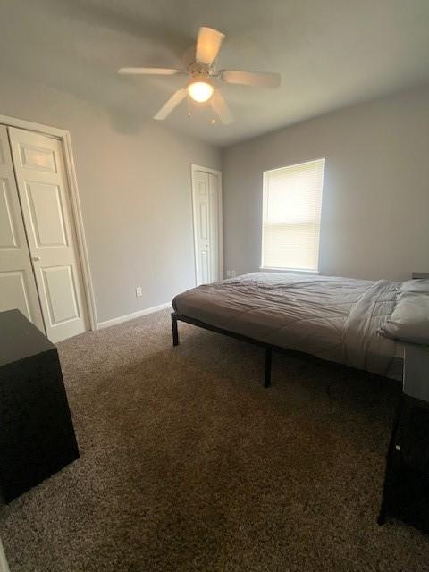 carpeted bedroom with a ceiling fan and baseboards