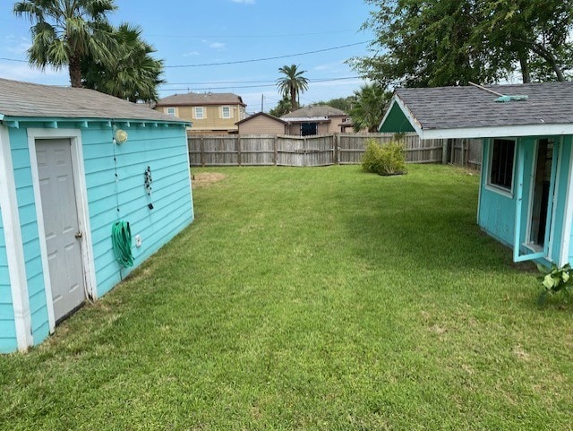 view of yard with a storage shed, an outdoor structure, and a fenced backyard