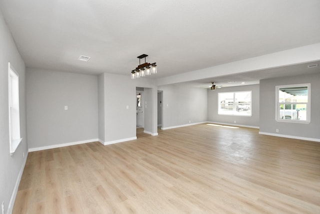 spare room with light wood-style floors, ceiling fan, and baseboards