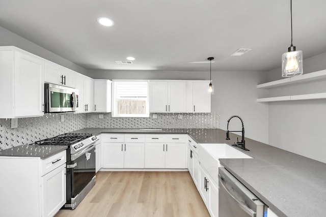 kitchen featuring a sink, visible vents, appliances with stainless steel finishes, light wood-type flooring, and open shelves