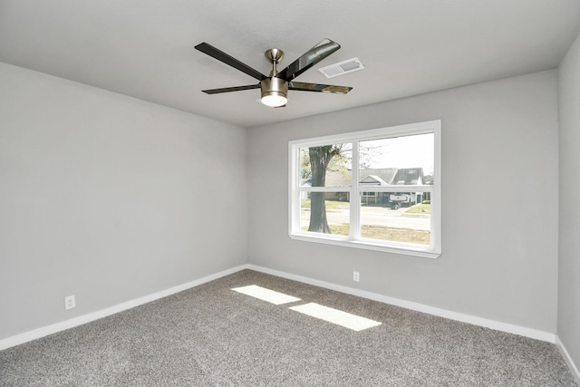 spare room with a ceiling fan, carpet, visible vents, and baseboards