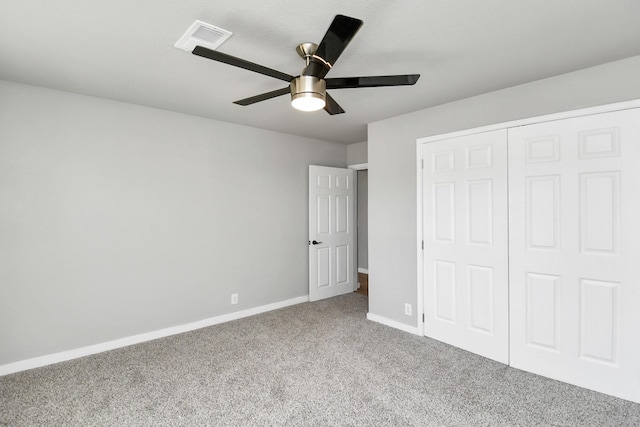 unfurnished bedroom with carpet floors, a closet, visible vents, a ceiling fan, and baseboards