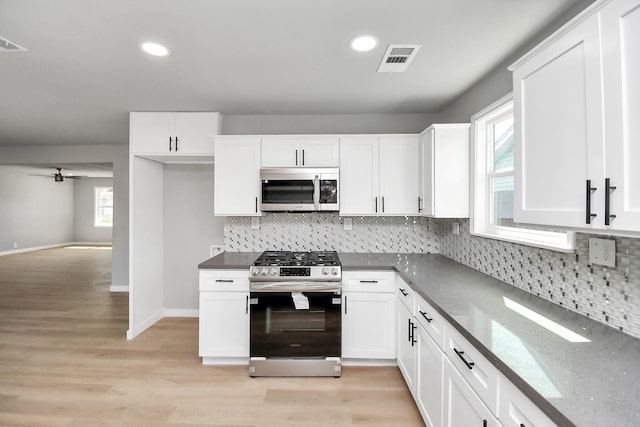 kitchen with stainless steel appliances, light wood-type flooring, visible vents, and white cabinets