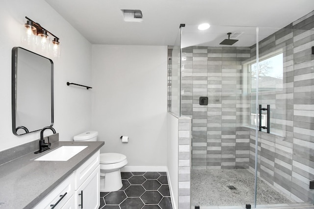 full bathroom featuring baseboards, toilet, tile patterned flooring, vanity, and a shower stall