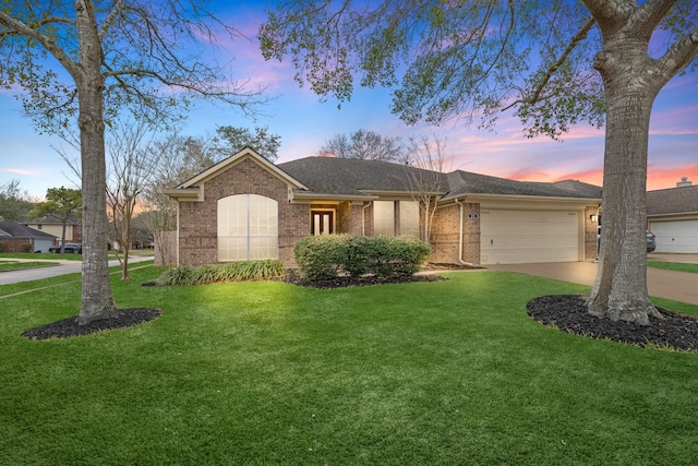 ranch-style home with a garage, driveway, a front yard, and brick siding