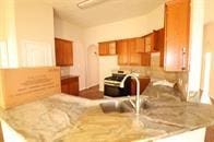 kitchen with a peninsula, brown cabinets, light countertops, and a sink