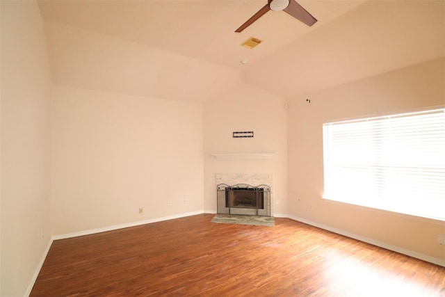 unfurnished living room featuring visible vents, a fireplace with flush hearth, a ceiling fan, vaulted ceiling, and wood finished floors