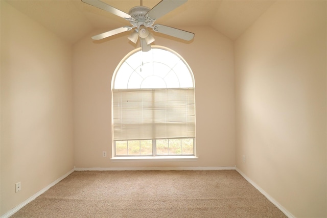 carpeted spare room featuring lofted ceiling, ceiling fan, and baseboards