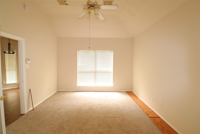 carpeted empty room with lofted ceiling, plenty of natural light, baseboards, and ceiling fan