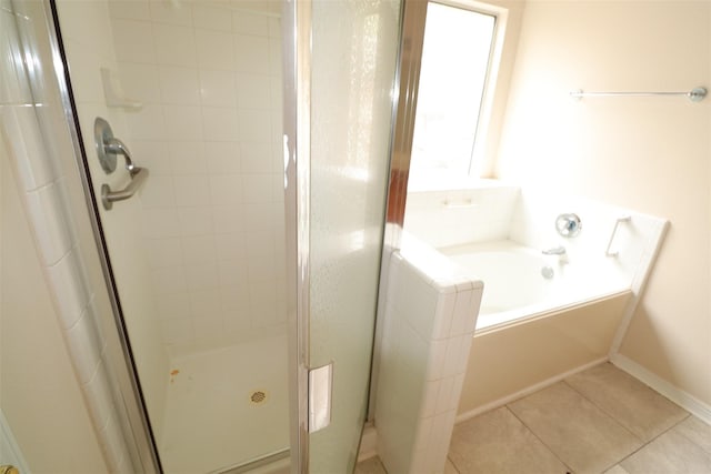 full bathroom featuring a stall shower, tile patterned flooring, and a garden tub