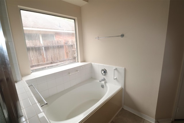 full bath featuring a garden tub and baseboards