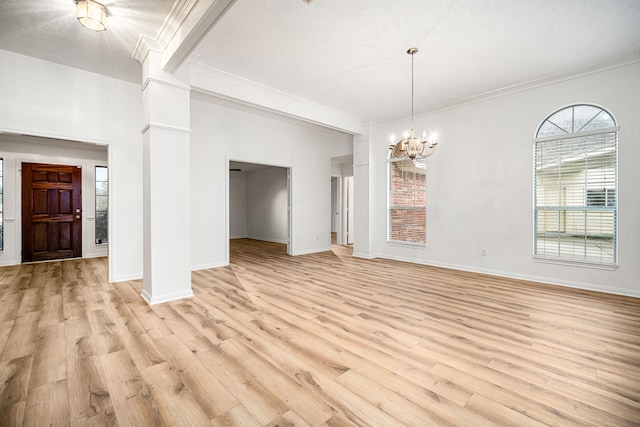 unfurnished dining area with crown molding, light wood finished floors, ornate columns, and an inviting chandelier