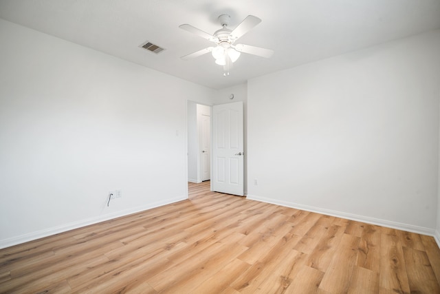 unfurnished room with a ceiling fan, visible vents, light wood-style flooring, and baseboards