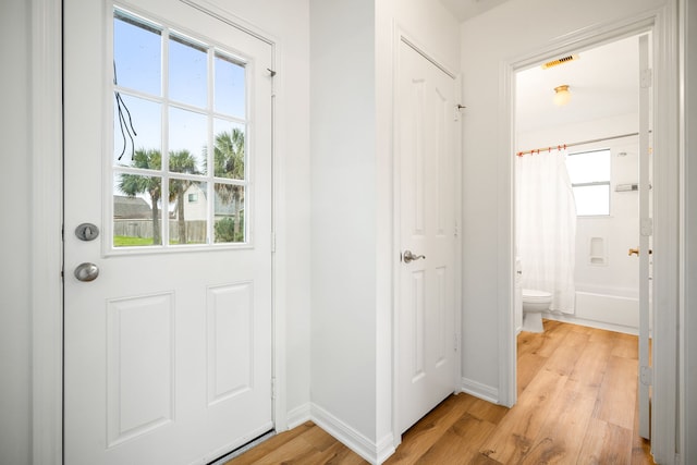 doorway to outside featuring light wood-style flooring and baseboards