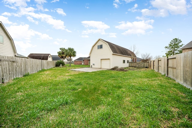 view of yard with a fenced backyard, a detached garage, a patio, and an outdoor structure