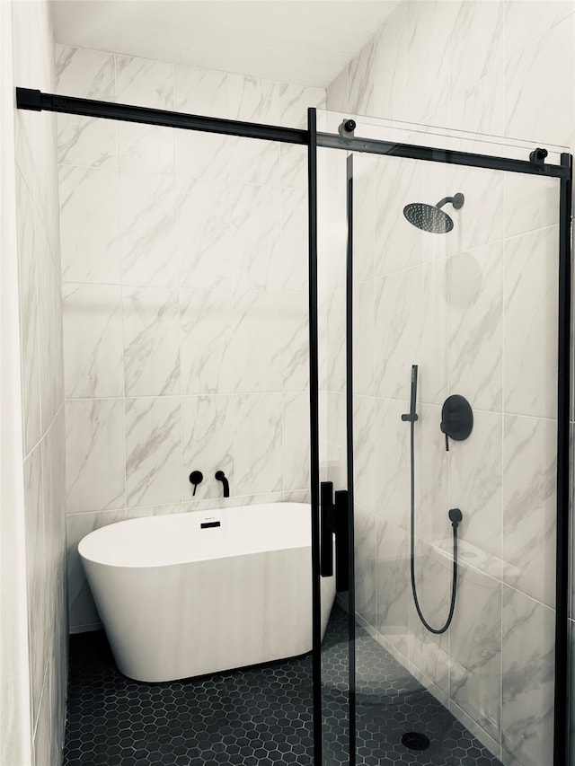 full bath featuring a freestanding tub, tile walls, and a shower stall