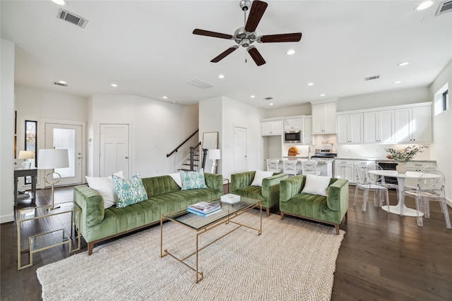 living room with recessed lighting, visible vents, dark wood-style floors, and stairway