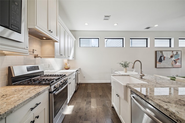 kitchen with visible vents, dark wood-style flooring, a sink, appliances with stainless steel finishes, and backsplash